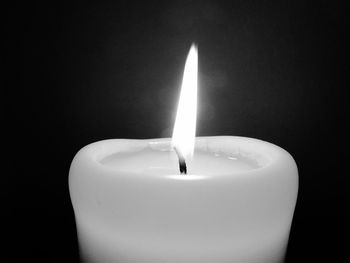 Close-up of illuminated candle against black background