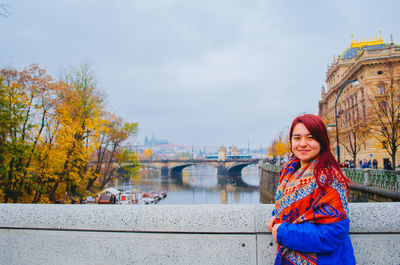 Portrait of smiling woman standing on bridge during autumn