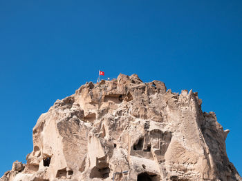 Low angle view of rock formation against clear blue sky