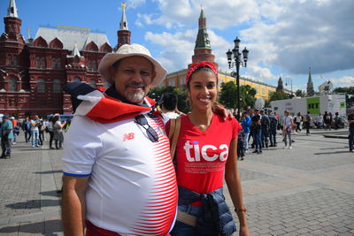 Portrait of happy friends with city in background