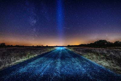 Empty road against sky at night