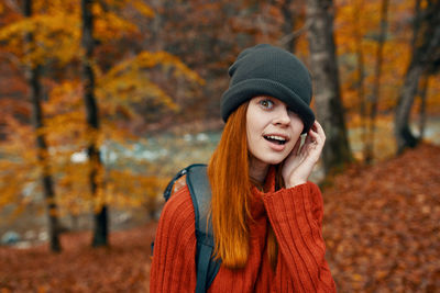 Portrait of smiling young woman in autumn leaves