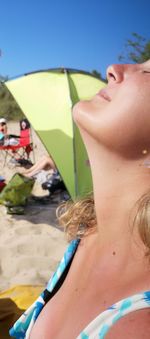 Midsection of woman on beach during sunny day