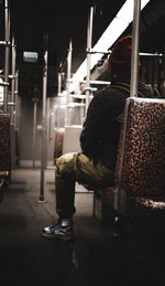 Rear view of man sitting in train