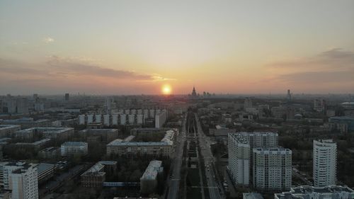 Aerial view of modern buildings in city against sky during sunset