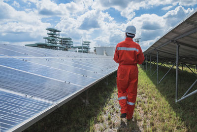 Rear view of man working against sky