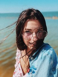 Portrait of woman wearing sunglasses at beach