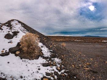 Scenic view of snow covered land against sky