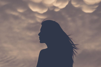 Silhouette woman against sky during sunset