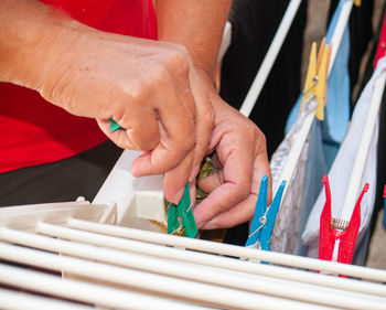 Midsection of man adjusting clothes on rack