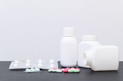 Close-up of bottles on table against white background