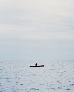 Man sailing on sea against sky