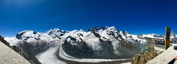 Scenic view of snowcapped mountains against clear blue sky