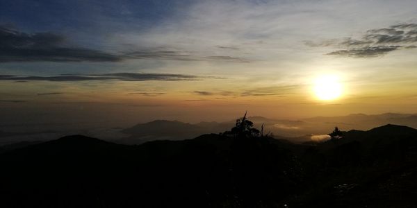 Scenic view of silhouette mountains against sky at sunset