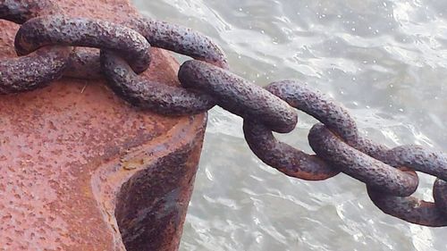 Close-up of rusty chain on sea