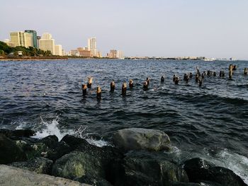 Scenic view of sea by city against sky