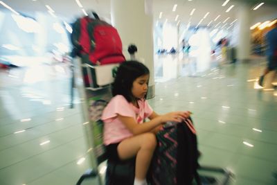 Girl sitting on illuminated subway station