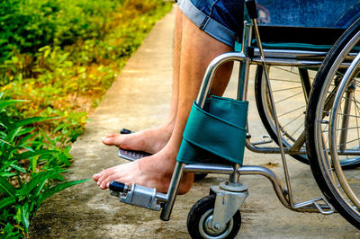 Low section of man sitting on wheelchair