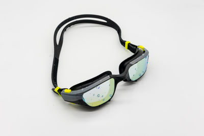 High angle view of eyeglasses on metal against white background