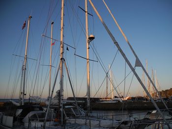 Boats moored at harbor during sunset