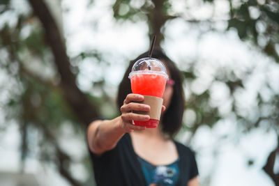 Close-up of woman holding ice cream cone outdoors