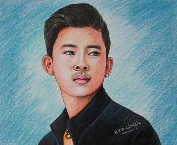 Portrait of young man standing against wall