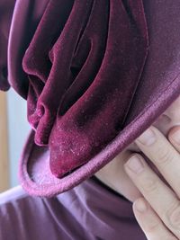 Close-up of hand holding purple flower
