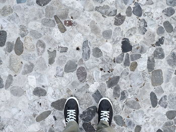 Low section of person standing on stone flooring