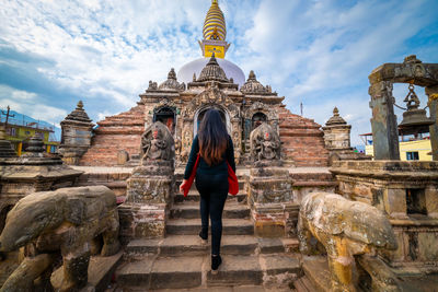 Woman visiting temple against building
