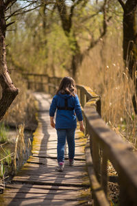 Rear view of woman walking on footpath