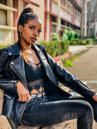 Young woman of color sitting on bench.