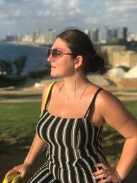 Young woman wearing sunglasses while standing outdoors