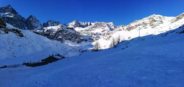 Scenic view of snowcapped mountains against clear blue sky