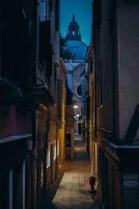 Alley amidst buildings in city at night