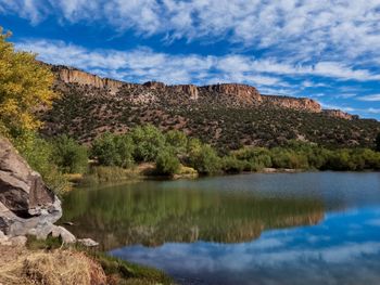 Scenic view of lake by mountain against sky