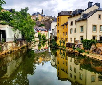 Canal amidst buildings in town against sky