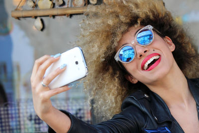 Happy woman in sunglasses taking selfie mobile phone