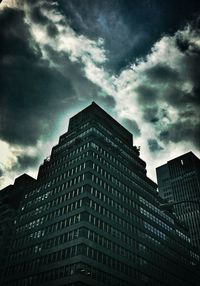 Low angle view of modern building against cloudy sky