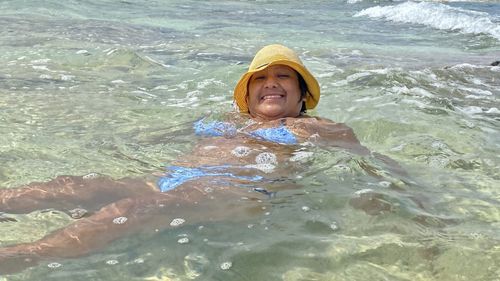 Portrait of smiling woman swimming in sea