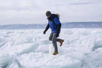 Full length of man standing on snow against sky