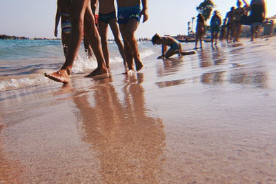 Low section of people on wet beach