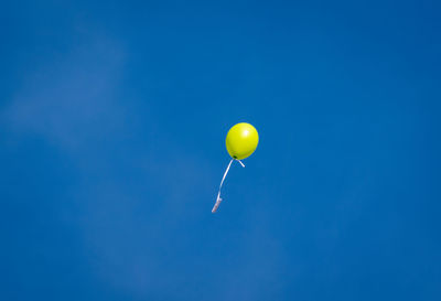 Low angle view of balloons against blue sky