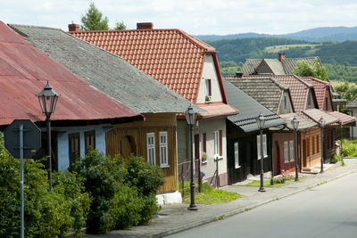 Houses by street and buildings against sky