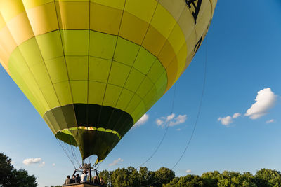 Low angle view of hot air balloon flying against blue sky
