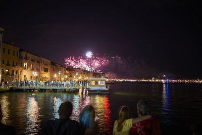 People by illuminated city at night