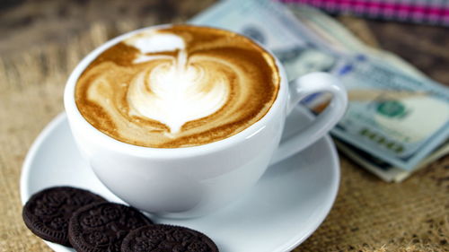 Close-up of cappuccino with biscuits on table