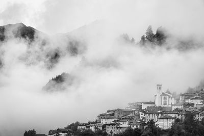 The village of villa dalegno, lombardia, italy, surrounded by clouds.