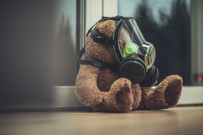 Close-up of stuffed toy with gas mask on floor