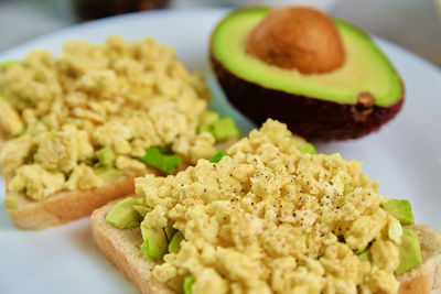 Toasts with avocado and egg on plate, healthy nutrition