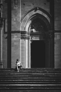 Rear view of woman standing on staircase of building